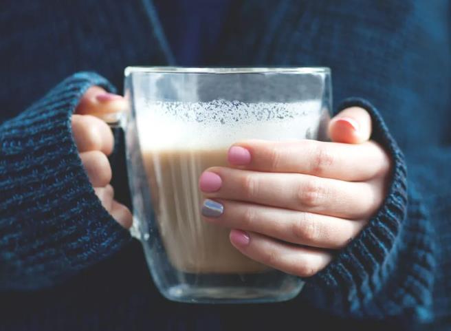 A-girl-holds-in-her-hands-the-double-wall-glass-filled-with-milk-tea